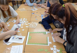 uczniowie klasy 1UA układają puzzle